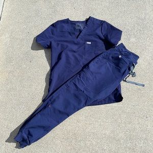 Blue Small Figs scrubs jogger pants with one stain on leg